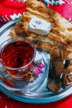 a glass plate with food on it and a cup of tea in front of it