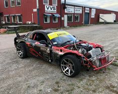 a car that is sitting on the ground in front of a building with its hood up