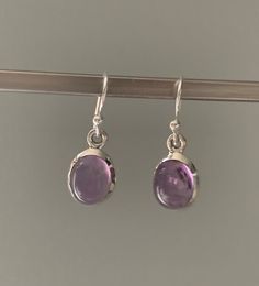 Amethyst oval earrings Classic Round Amethyst Earrings, Purple Amethyst Birthstone Earrings, Dainty Nickel-free Purple Earrings, Dainty Purple Nickel-free Earrings, Silver Dainty Earrings With Polished Finish, Sterling Silver Oval Earrings With Ear Wire, Dainty Polished Finish Earrings For Gift, Dainty Silver Earrings With Polished Finish, Dainty Polished Earrings As A Gift