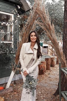 a woman standing in front of a tree