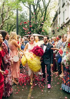 a man and woman are walking down the street with confetti