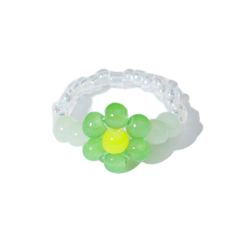 a green and yellow beaded ring on a white background