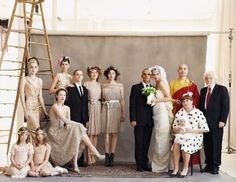 a group of people standing next to each other in front of a wall with a ladder