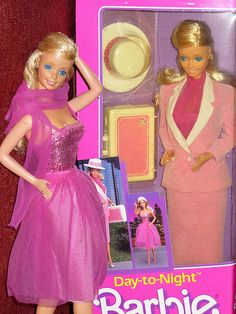 the barbie doll is wearing a pink dress and matching hat with her hair in a bun