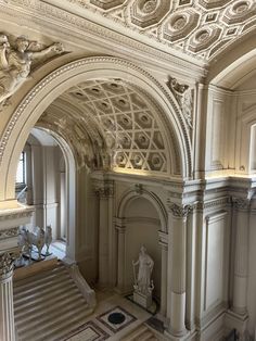 an ornate archway in the center of a building with statues on either side and stairs leading up to it