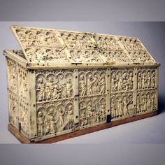 an elaborately carved wooden box with figures on the front and sides, in white