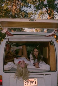 two women laying in the back of a van