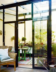 a patio with chairs, tables and potted plants