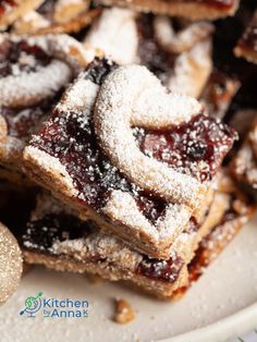 powdered sugar and jelly filled desserts stacked on top of each other in a white plate