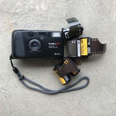 a digital camera sitting on top of a table next to other electronics and accessories,