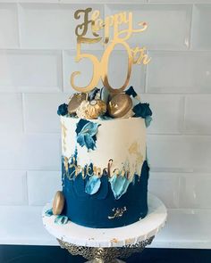 a blue and white cake with gold decorations