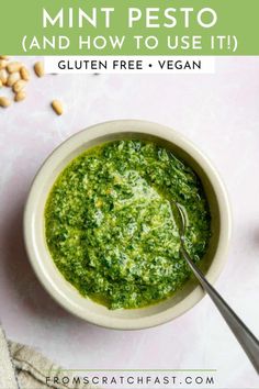 a white bowl filled with pesto and topped with cashews on the side