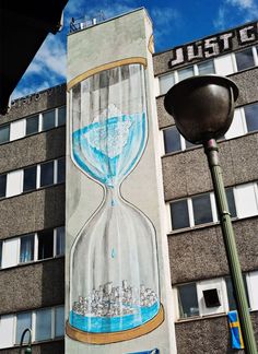 a mural on the side of a building with an hourglass in front of it