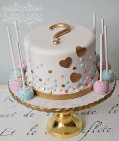 a white cake with pink, blue and gold decorations