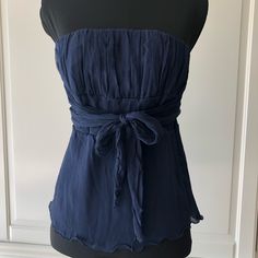 This Blue, Silk, Strapless Empire Waist Blouse With Straight Across Neckline Has 52” Wrap Belts Attach On Each Made To Be Wrap Twice And Then Tie Into A Simple Knot Of Bow Either At The Front Or Back Of The Waistline. New, Never Worn Because Runs Smaller Than The Medium Size. It’s Best Fitted For Extra Small. Blue Sleeveless Blouse For Night Out, Elegant Blue Sleeveless Blouse, Chic Blue Evening Top, Blue Strapless Tops For Summer, Blue Summer Blouse For Night Out, Blue Blouse For Summer Night Out, Elegant Strapless Summer Blouse, Elegant Blue Sleeveless Tube Top, Casual Blue Tube Top For Party