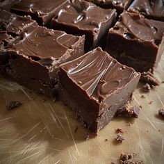 pieces of chocolate cake sitting on top of a wooden cutting board