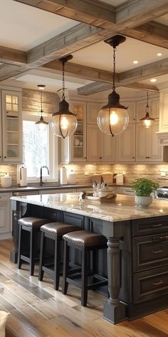 a kitchen with an island and stools in the center, lights hanging from the ceiling