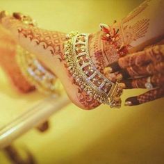 a woman's feet with hennap and jewelry on her hands, in front of a mirror