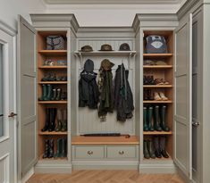 a walk in closet filled with lots of shoes and coats on top of wooden shelves