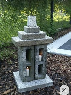 an outdoor candle holder made out of concrete blocks