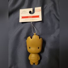 a keychain shaped like a baby groote is hanging on a bed