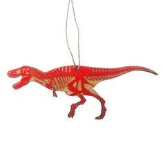 a red dinosaur ornament hanging from a string