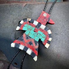 This Kewa thunderbird bolo is a 2023 reproduction of the "battery birds" of the Depression Era. It was made by Kewa artist Robert Rosette, using a vintage LP album as the backing. The original battery birds came out of The Great Depression, when materials were scarce and artists in the pueblo used plastics from vinyl batteries and LPs in place of some of their standard materials, such as black onyx and coral. This piece uses many of those same materials. Native Necklace, Native American Earrings, Native American Rings, Lp Album, Lp Albums