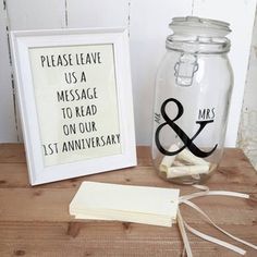 there is a glass jar with a sign on it next to a small card holder