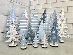 several wooden trees are standing next to each other in front of a white brick wall