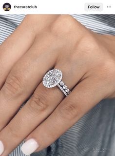 a woman's hand with a ring on her finger and an oval diamond in the middle