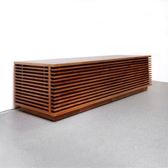 a large wooden object sitting on top of a white floor in front of a wall