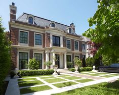 a large house with lots of windows and grass on the ground in front of it