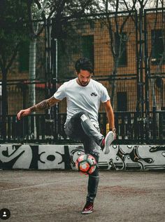 a man kicking a soccer ball on top of a field