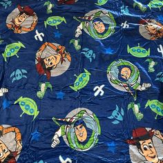 a blue blanket with cartoon characters on it and stars in the sky around them, as if they were from toy story books