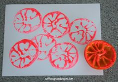 an orange is sitting on top of a piece of paper next to some cut up fruit