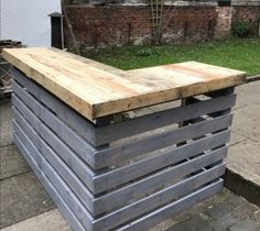 an outdoor bar made out of pallets and wooden planks on the side of a building