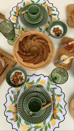 a table set with plates, bowls and utensils