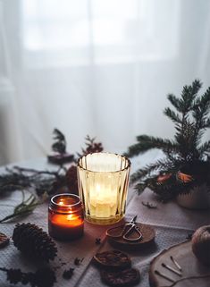 a candle and some pine cones on a table