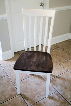 a wooden chair sitting on top of a tiled floor