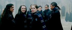 a group of women standing next to each other in front of a building on a foggy day