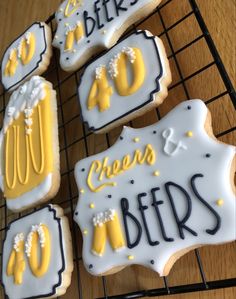 some decorated cookies on a cooling rack with the words cheers and beers written on them