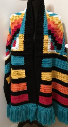 a colorful crocheted jacket hanging on a wall