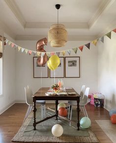 a dining room table with balloons hanging from the ceiling