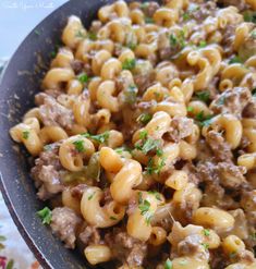 a skillet filled with macaroni and cheese on top of a floral table cloth