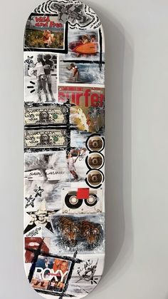 a skateboard covered in pictures and stickers is hanging on the wall with it's wheels