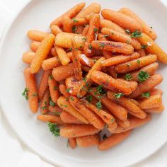 a white plate topped with carrots covered in parsley