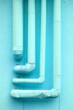 pipes are attached to the side of a pink wall