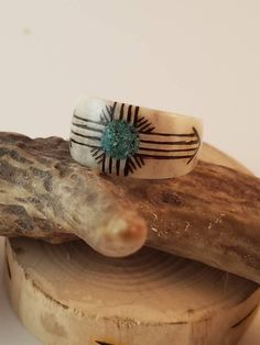 Handcarved Deer Antler Ring. Native American inspired Sun design with Turquoise Inlay.  Made to order in your size.  Deer antler color will vary slightly due to the NATURAL grain.   * All rings are crafted from naturally shed Illinois Whitetail Deer antler.  No deer were hurt in the making. *No Returns permitted for antler rings, since each one is made to order. * Message me for custom requests! deer antler ringantler ringantler ziasunturquoiseinlayringwomen's antler ringmen's antler ringhypoallergenic ring Deer Horn Jewelry, Zia Sun Symbol, Deer Antler Crafts, Deer Antler Jewelry, Antler Rings, Deer Antler Ring, Antler Carving, Hand Carved Ring, Antlers Decor