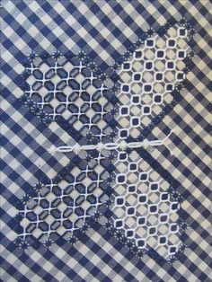 the blue and white checkered fabric has been stitched together to make an intricate pattern