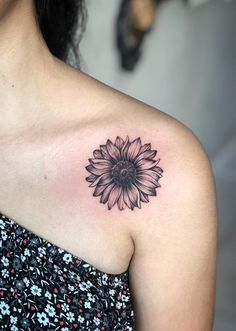 a woman's shoulder with a sunflower tattoo on her left arm and chest